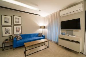 sala de estar con sofá azul y TV en BHomy Brooklin Ao lado do WTC e Berrini ET802, en São Paulo