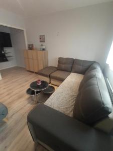 a living room with a couch and a table at Studio cosy à 10 minutes du centre-ville. in Saint-Étienne