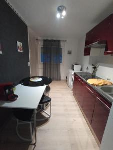 a kitchen with a table and a counter top at Studio cosy à 10 minutes du centre-ville. in Saint-Étienne