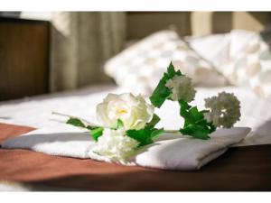 un ramo de flores blancas sentado en la parte superior de una cama en Tabata Oji Hotel - Vacation STAY 89860v, en Tokio