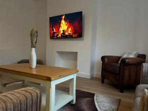 a living room with a table and a fire on the wall at NEW! 3 Bed House with Pool Table, Parking, Netflix in Nottingham