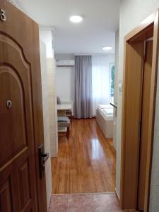 Zimmer mit einem Flur mit einer Tür und einem Wohnzimmer in der Unterkunft Apartment Atina in Subotica