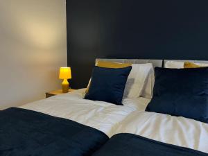 Una cama con dos almohadas azules encima. en NEW! 3 Bed House with Pool Table, Parking, Netflix en Nottingham