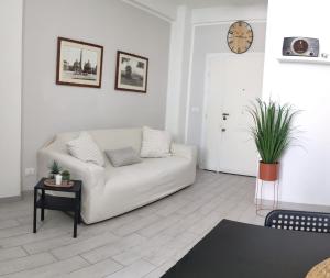 ローマにあるAppartamentoの白いリビングルーム(白いソファ、時計付)