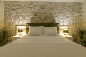 a bedroom with a large bed with two lamps at Sobe Bartul Trogir in Trogir