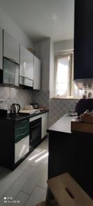 ローマにあるAppartamentoのキッチン(白と黒の電化製品付)、窓