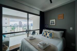 une chambre avec un lit et une grande fenêtre dans l'établissement BHomy VN, à São Paulo