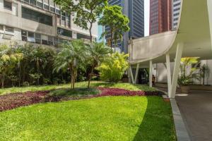 a garden in the middle of a building with palm trees at BHomy Paulista Na Av Paulista com design BA608 in São Paulo