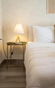 a bed with a table with a lamp on it at Maisonette Pylos in Pylos