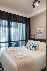 une chambre avec un grand lit avec des serviettes dessus dans l'établissement BHomy VN, à São Paulo