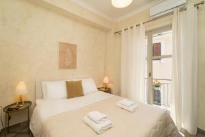 - une chambre avec un grand lit blanc et des serviettes dans l'établissement Maisonette Pylos, à Pylos