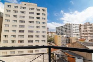 un balcone con vista su un grande edificio bianco. di BHomy Avenida a San Paolo