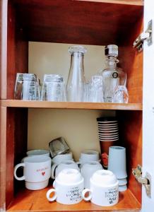 ein Regal mit Tassen und Glasflaschen in der Unterkunft Horizon heights 2 in Kira