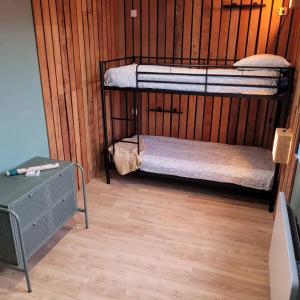 two bunk beds in a room with a wooden wall at La Buguoise in Le Bugue
