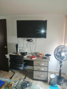 biurko z monitorem na ścianie i wentylatorem w obiekcie habitacion amoblada con baño w mieście Bucaramanga