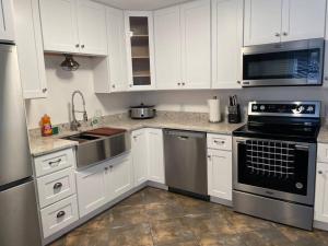 a kitchen with white cabinets and stainless steel appliances at Updated,spacious, maritime 3BR downtown cottage in Saint Augustine +9 photos