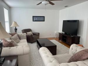 a living room with couches and a flat screen tv at Updated,spacious, maritime 3BR downtown cottage in St. Augustine