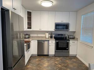a kitchen with white cabinets and black appliances at Updated,spacious, maritime 3BR downtown cottage in St. Augustine