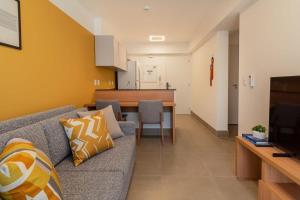 uma sala de estar com um sofá e uma sala de jantar em BHomy Perdizes Novo e perfeito para 4 DH302 em São Paulo