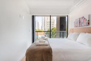 a bedroom with a large bed with two towels on it at BHomy Perdizes Novo e perfeito para 4 DH302 in São Paulo
