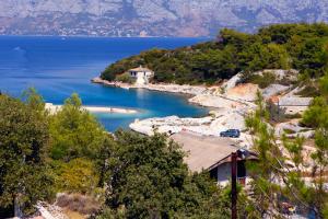 una casa en una colina al lado de un cuerpo de agua en Holiday House Doda, en Povlja