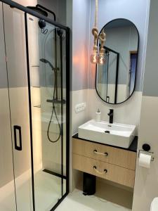 uma casa de banho com um lavatório e um espelho em Blue Apartament - HOME APART em Ostróda