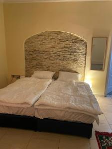 a bedroom with a large bed with a brick wall at شقق 5د من الحرم النبوي Apartments 5mins near Masjid Nabawi in Al Madinah