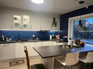 a kitchen with white cabinets and a table with chairs at Arendalsuka - Fin enebolig, sentralt og sjønært,gratis parkering 4 rom 3 bad 2 stuer in Arendal +33 photos