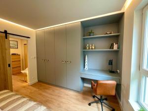 um quarto com uma secretária e uma cadeira num quarto em Blue Apartament - HOME APART em Ostróda