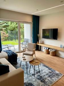 uma sala de estar com um sofá e uma televisão em Blue Apartament - HOME APART em Ostróda