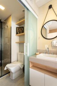 een badkamer met een wastafel, een toilet en een spiegel bij BHomy VMadalena - Com vista de Sampa UP310 in Sao Paulo