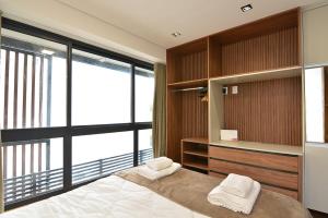 a bedroom with a bed and a large window at BHomy Perdizes - Piscina com vista de Sampa VA410 in Sao Paulo