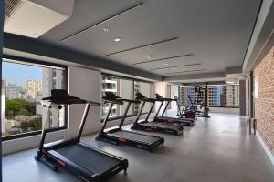 a row of treadmills in a gym with windows at BHomy Perdizes - Piscina com vista de Sampa VA410 in Sao Paulo