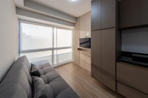 a living room with a couch and a large window at BHomy Perdizes - Garagem e piscina c vista VA802 in Sao Paulo