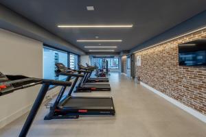 a row of treadmills in a gym with a brick wall at BHomy Perdizes - Garagem e piscina c vista VA802 in Sao Paulo