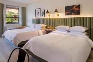 a hotel room with three beds and a window at The Lodge at Zion Country in Springdale