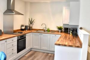 a kitchen with white cabinets and a sink at *Penthouse Luxury Apartment 2min to City in Carlisle