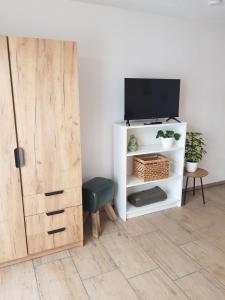 ein Wohnzimmer mit einem TV und einem weißen Schrank in der Unterkunft Ferienwohnung Alte Landstube in Hürtgenwald