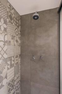 een douche met een glazen deur in de badkamer bij BHomy Jardins Charme e estilo HB1911 in Sao Paulo