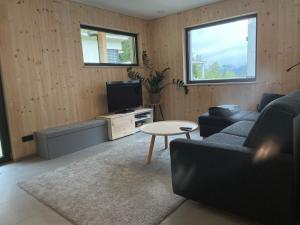 uma sala de estar com um sofá e uma televisão em Waldblick - modern wohnen - Self-Check-In - direkt am Wald - kein Verkehr - in 10 Minuten im Innsbrucker Zentrum - vorm Haus parken em Innsbruck