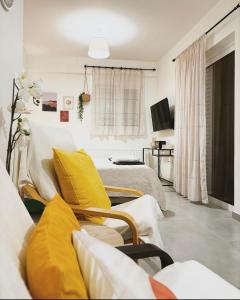 uma sala de estar com duas camas e uma televisão em Liakada Guest House em Artemida