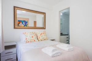 um quarto com uma cama branca e um espelho em BHomy Anhembi Excelente localização AB132A em São Paulo