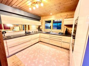 a large kitchen with wooden walls and wooden floors at Les Villas d' Onalou Port Blanc in Penvénan