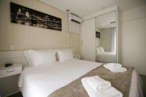een slaapkamer met een wit bed en handdoeken bij BHomy Jardins Agradável perto da Paulista PF104 in Sao Paulo
