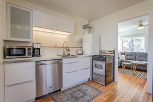 a kitchen with white cabinets and stainless steel appliances at Vintage Tiny House CUTE 1BDRM Big Appeal in Colorado Springs