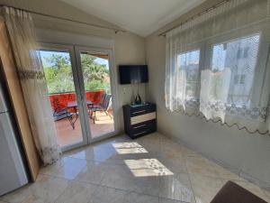 a living room with a sliding glass door with a view of a patio at Callistemon Loft Apartment in Potos
