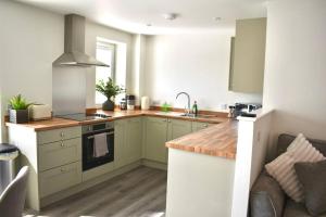 cocina con armarios verdes y fogones horno superior en *Luxury Apartment 2min from City en Carlisle