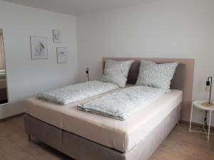 ein Bett mit zwei Kissen auf einem Zimmer in der Unterkunft Ferienwohnung Alte Landstube in Hürtgenwald