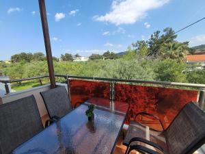 a table and chairs on a balcony with a view at Callistemon Loft Apartment in Potos
