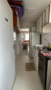 a small kitchen with a stove and a refrigerator at Apartamento Pé na Areia - Praia Grande in Praia Grande